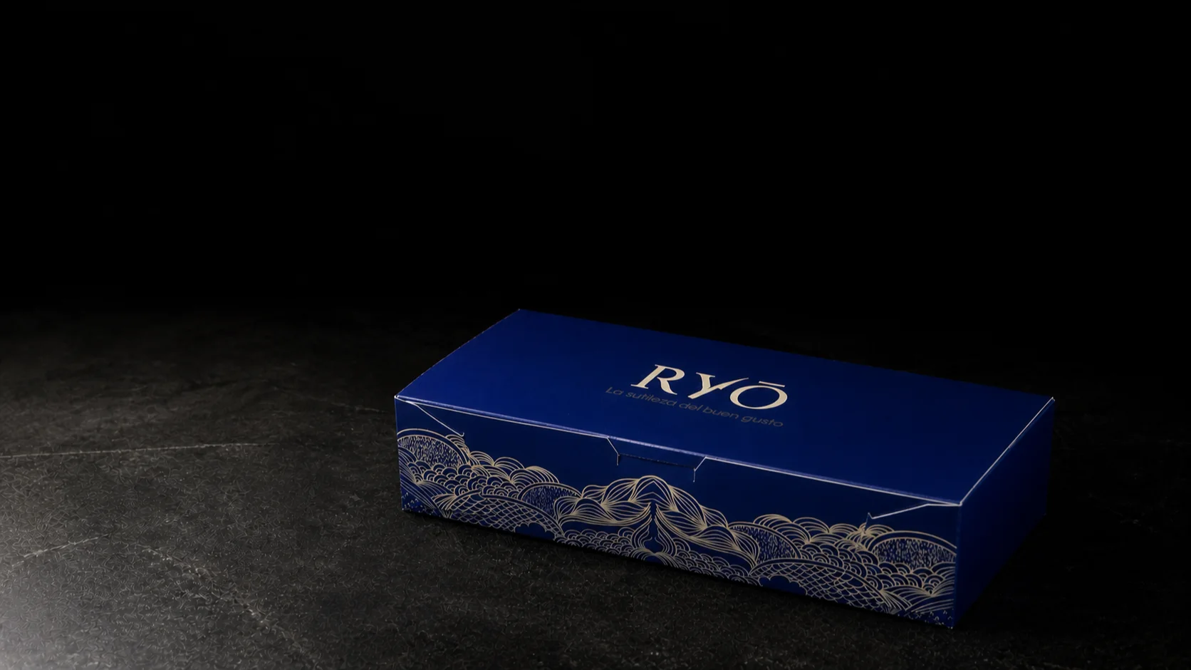 Caja azul RYŌ cerrada sobre una mesa de estudio