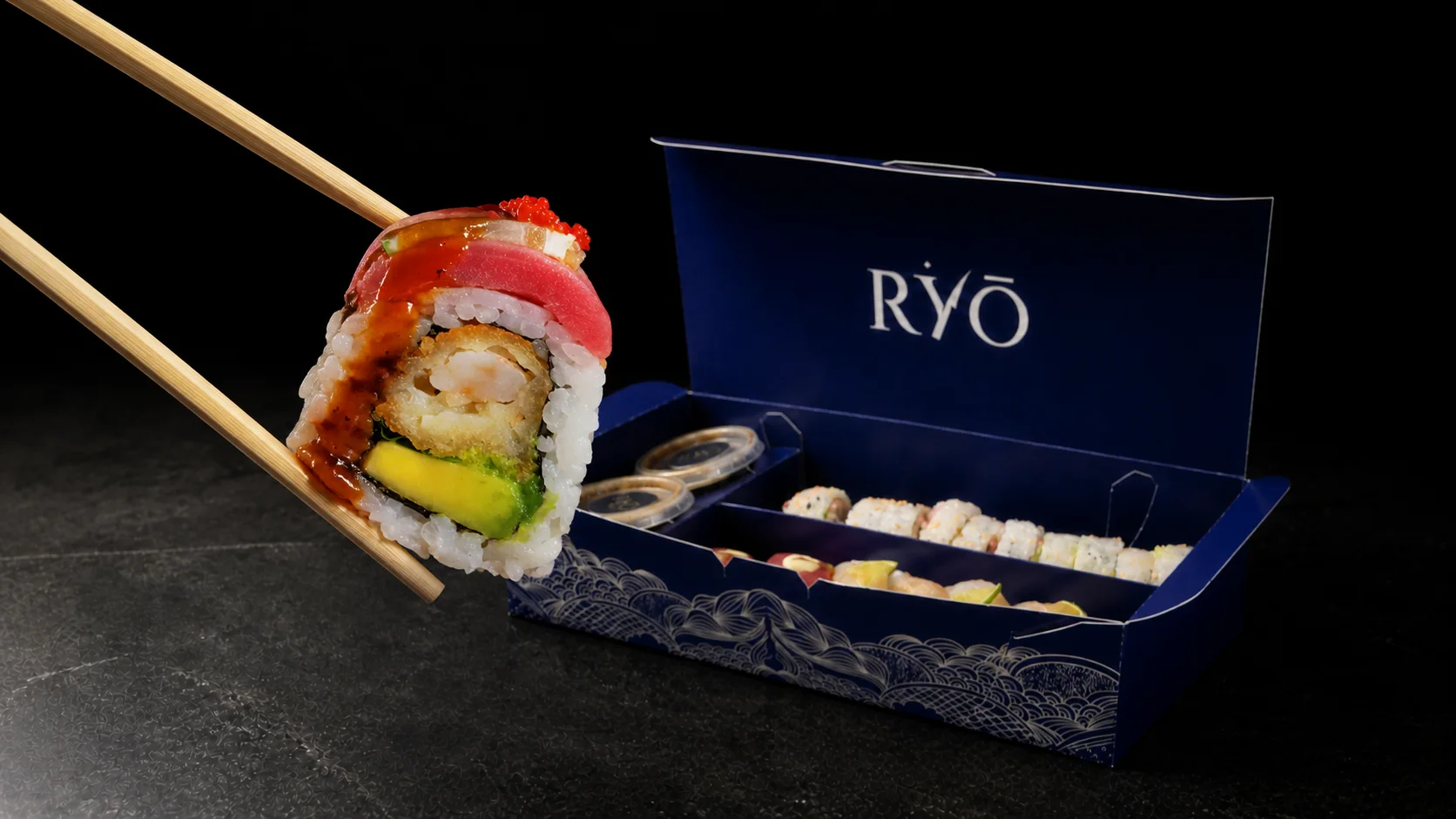 Roll Sei Exclusive sostenido con palillos frente a la caja azul RYŌ
