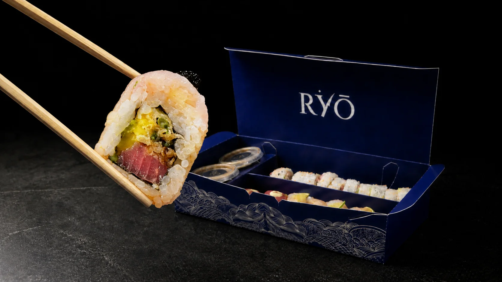 Roll Yuzu sostenido con palillos frente a la caja azul RYŌ